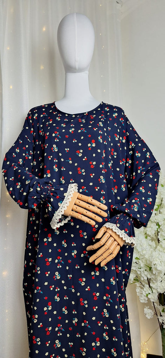 Vorderansicht des „Floral Noor“ Outfits mit lockerem Schnitt und Blumenprint auf dunkelblauem Stoff