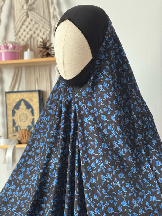 Islamischer Jilbab Qahira Flowers in Schwarz mit blauen Blumen. Vorderansicht.
