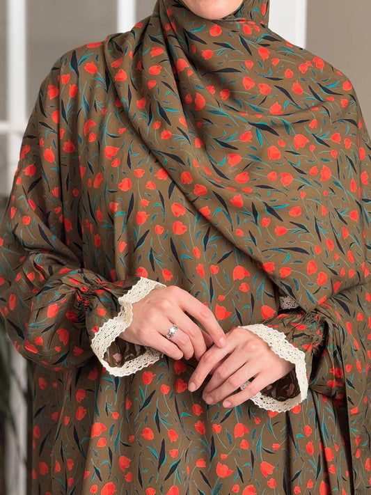 Nahaufnahme der Ärmel mit weißer Spitzenbordüre und elegantem Faltenwurf.