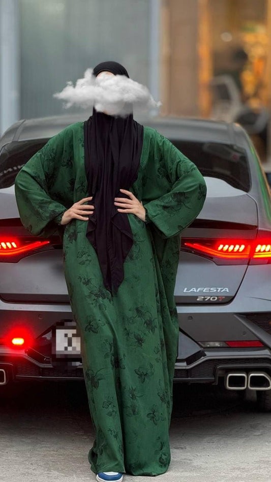 Vorderansicht Abaya Rawdah. Hände an der Hüfte und angelehnt.