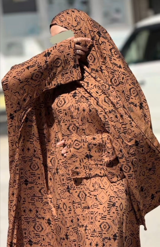 Abaya Jannah mit ornamentalen Mustern in warmem Braunton, traditionell inspiriert und elegant.