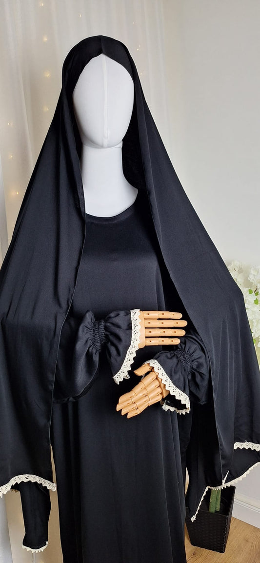 Vorderansicht der Abaya Qamar Black mit cremefarbenen Spitzendetails an Ärmeln und Khimar.