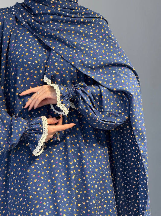 Detailaufnahme des Ärmels mit gesmoktem Bündchen und floraler Struktur.