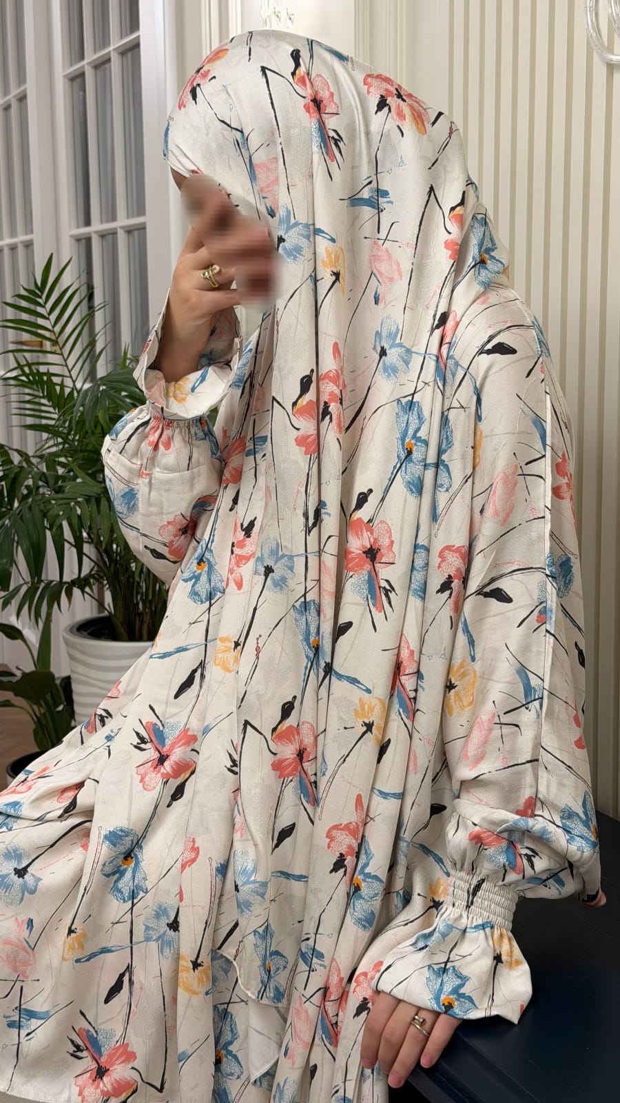 Detailaufnahme der weißen Abaya mit buntem floralem Print