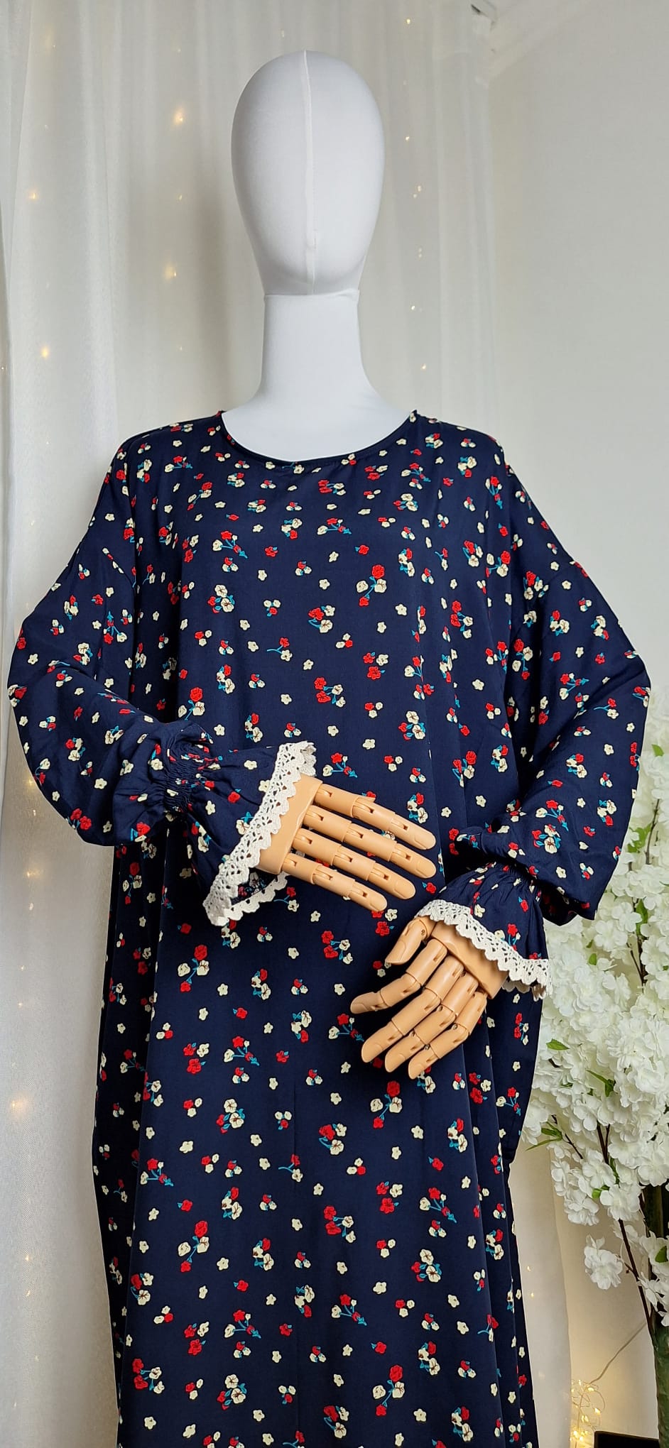 Dunkelblaues Kleid Floral Noor mit Spitzenrüschen an den Ärmeln.