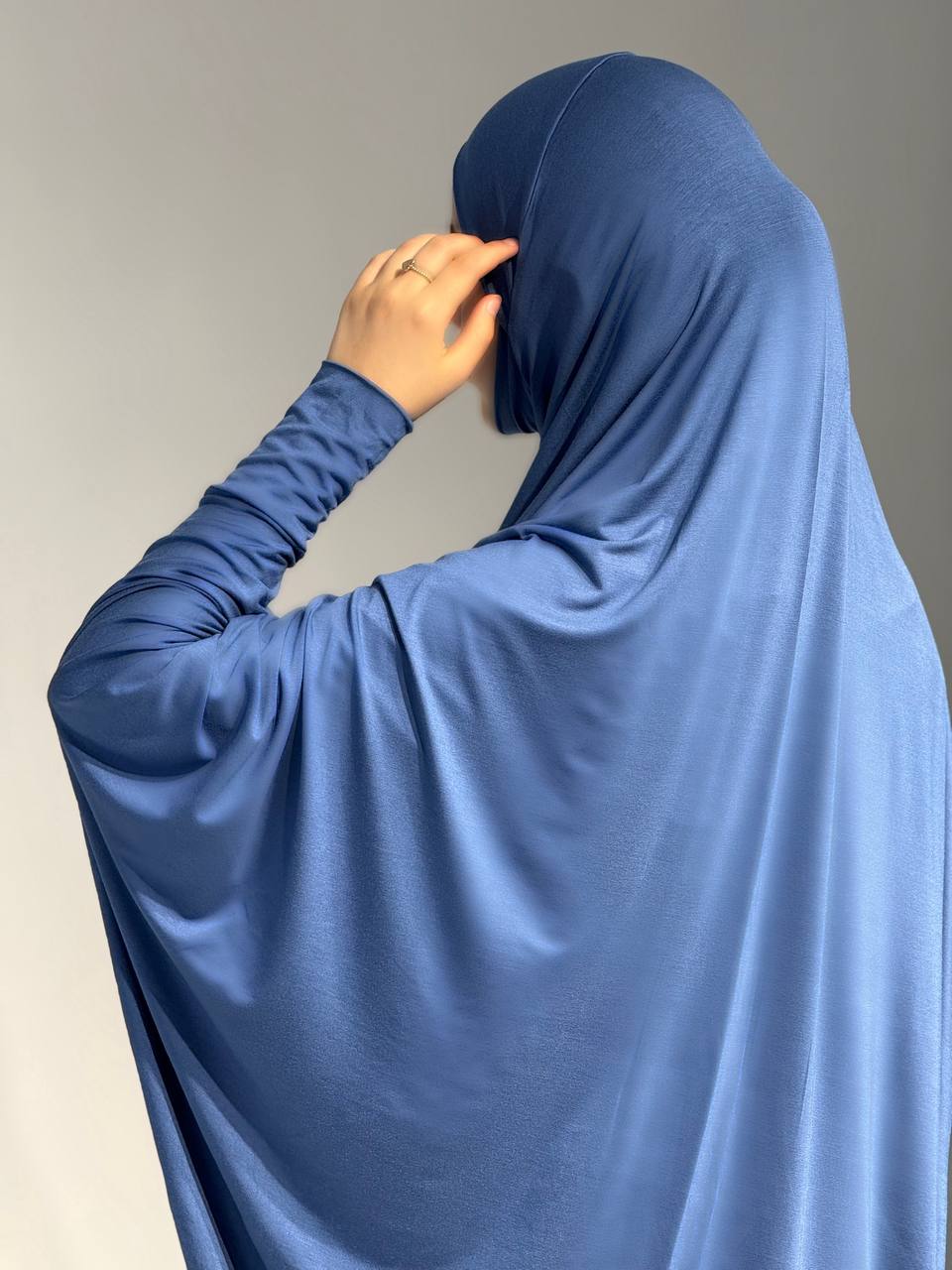 Rückansicht des Jilbab Azraq Ocean, Kopf seitlich abgewendet, zeigt das lange, weich fallende Rückenteil.